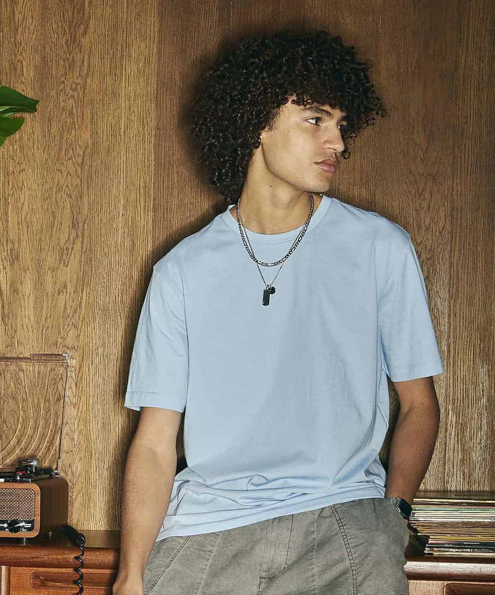 Young man wearing a light blue embroidered T-shirt for casual or workwear.
