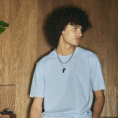 Young man wearing a light blue embroidered T-shirt for casual or workwear.
