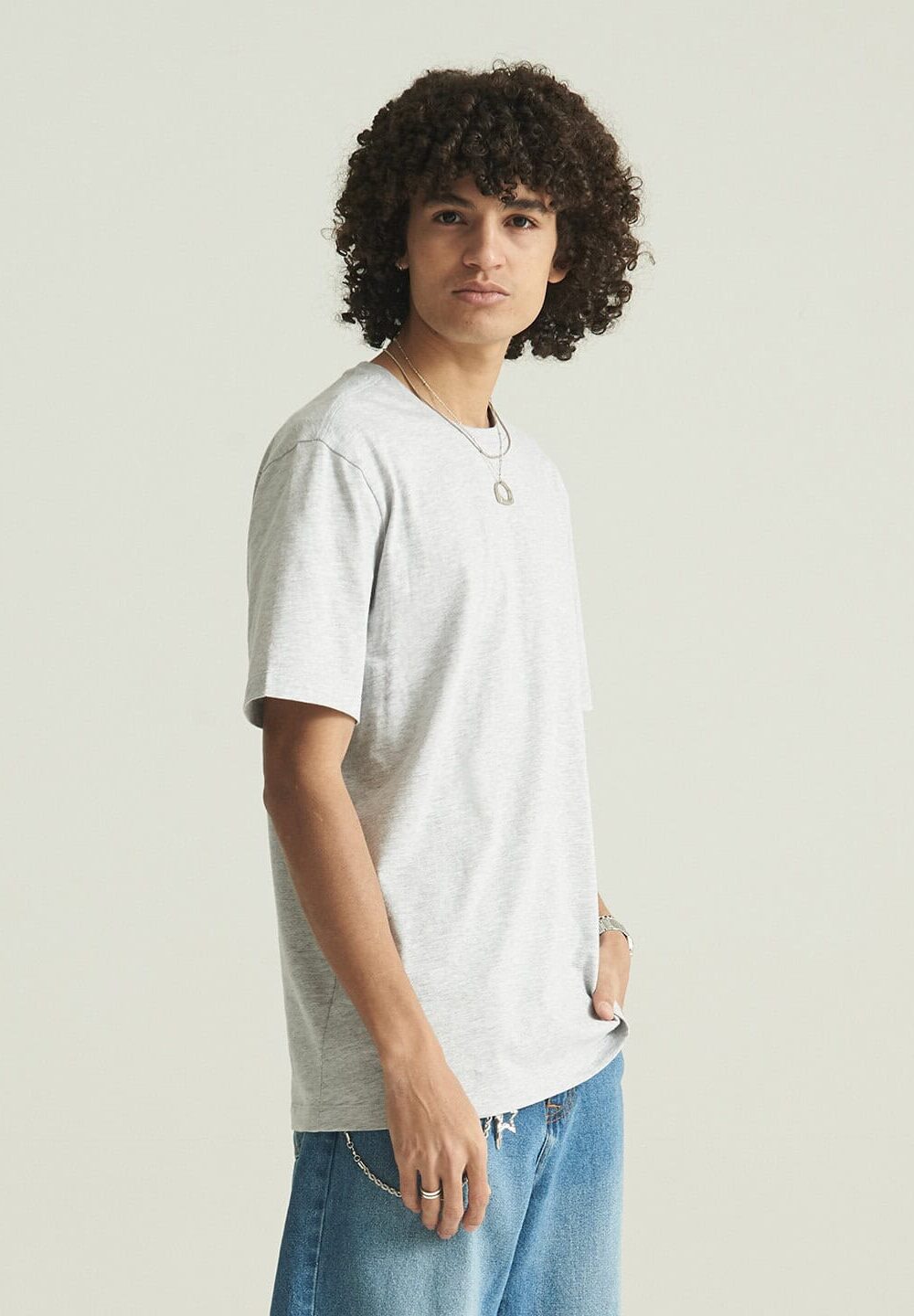 Natural light grey casual t-shirt, suitable for personalised embroidery and workwear, paired with light blue jeans, ideal for uniform branding and promotional garments.