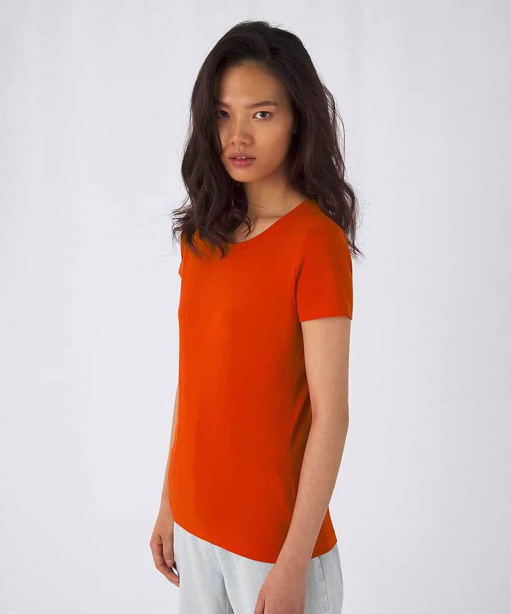 Woman wearing an orange embroidered T-shirt, casual style.