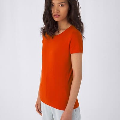 Woman wearing an orange embroidered T-shirt, casual style.
