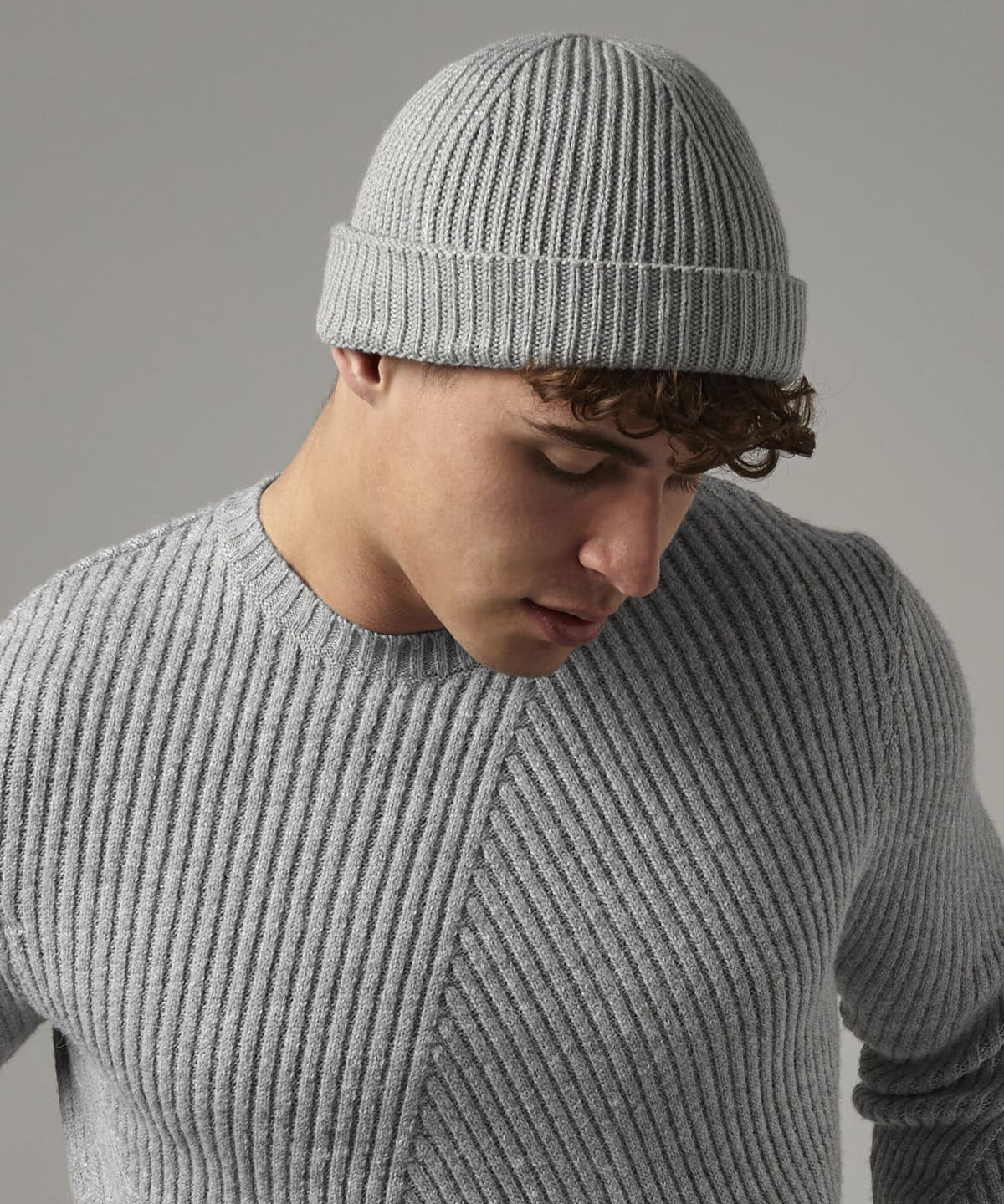 Soft grey knitted beanie hat on a male model, perfect for customised workwear and promotional uniforms.