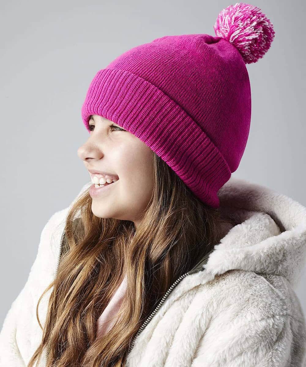 Junior Snowstar Beanie in vibrant pink with pom-pom.