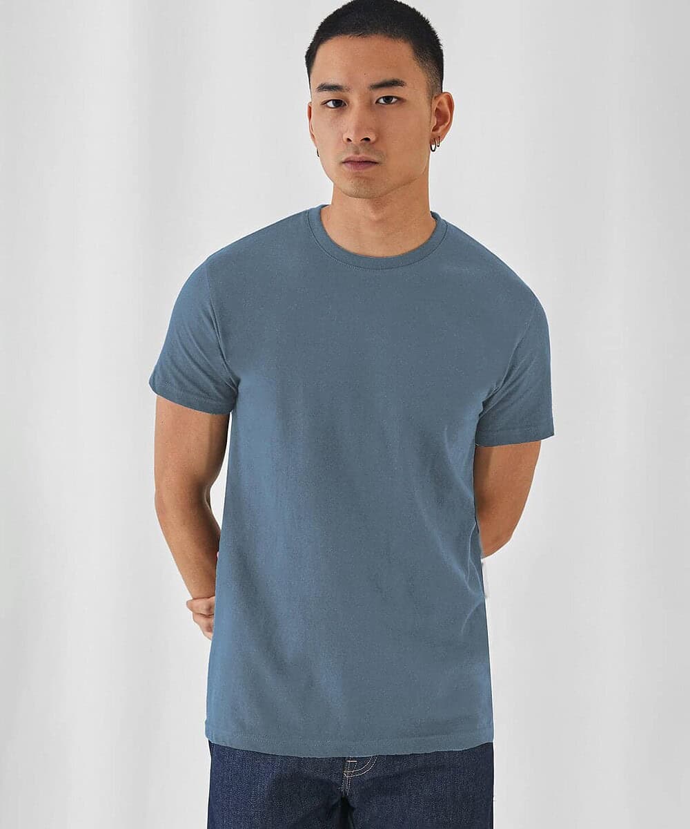 Man wearing a plain blue T-shirt, ideal for custom embroidery and printing.