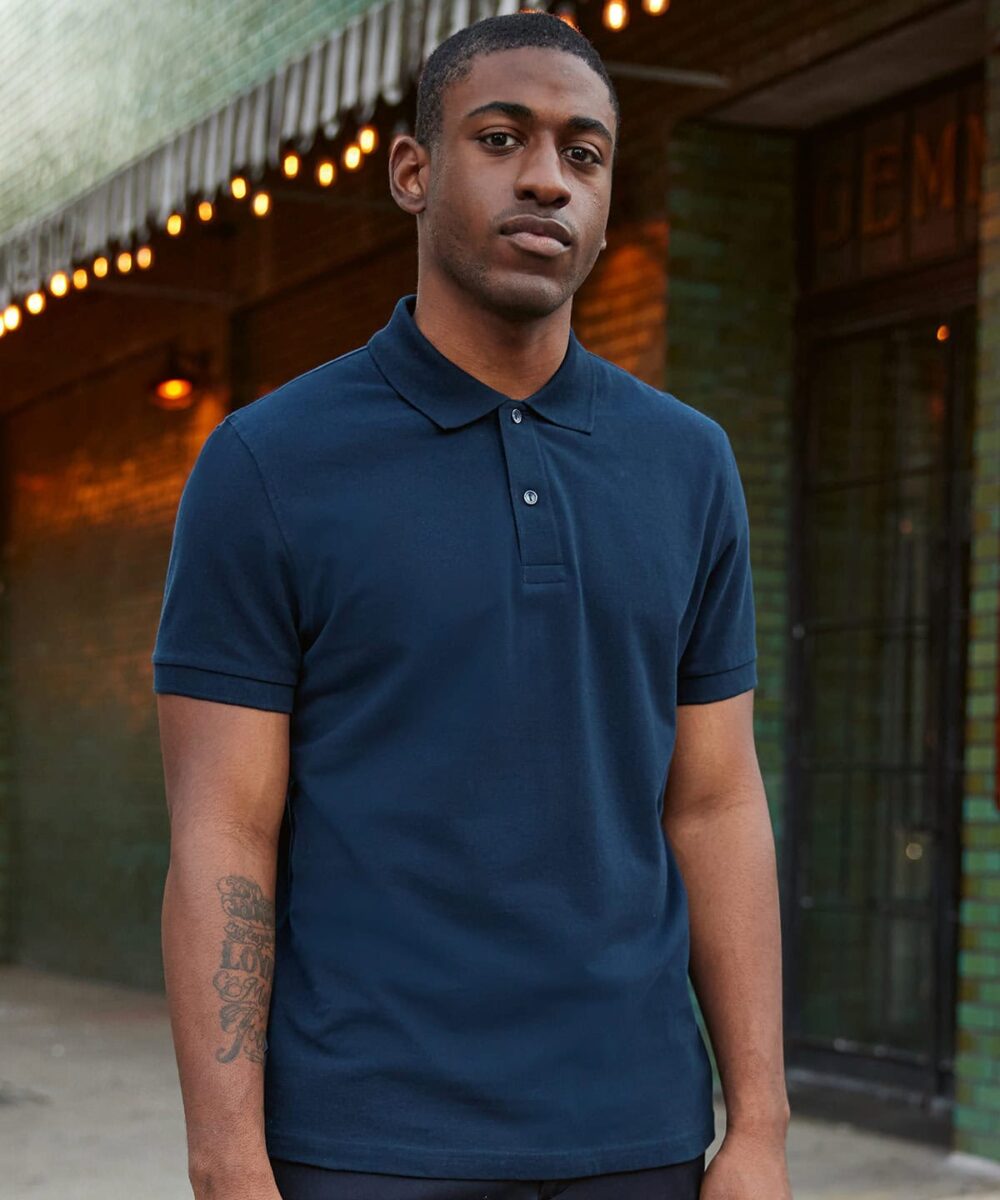 Man wearing navy blue polo shirt for work or casual uniform settings.