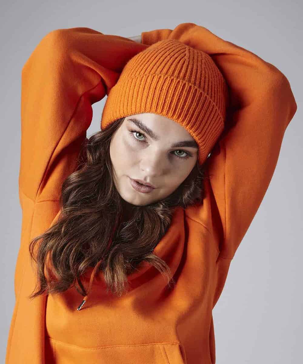 Orange knitted beanie hat with ribbed design, ideal for custom embroidery.
