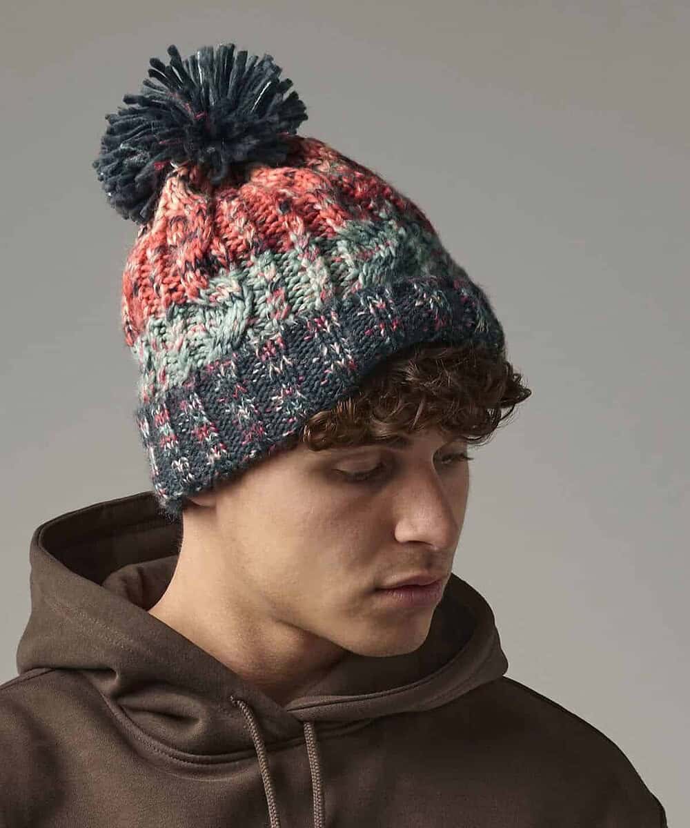 Corkscrew pom-pom beanie with colourful knit pattern, perfect for custom embroidery and winter wear.