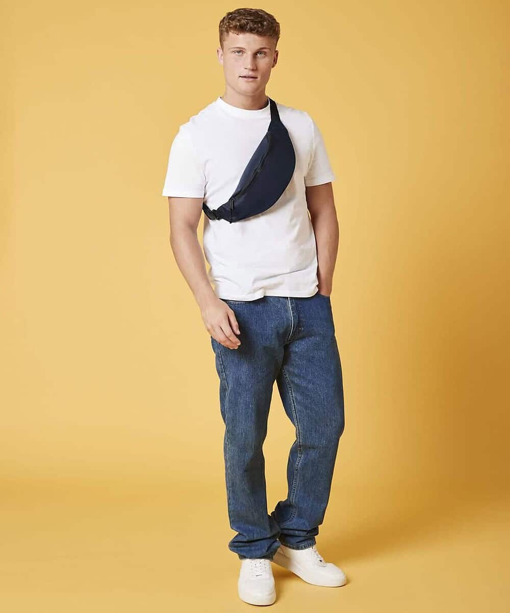Recycled waistpack worn across the chest by a young man against a yellow background.