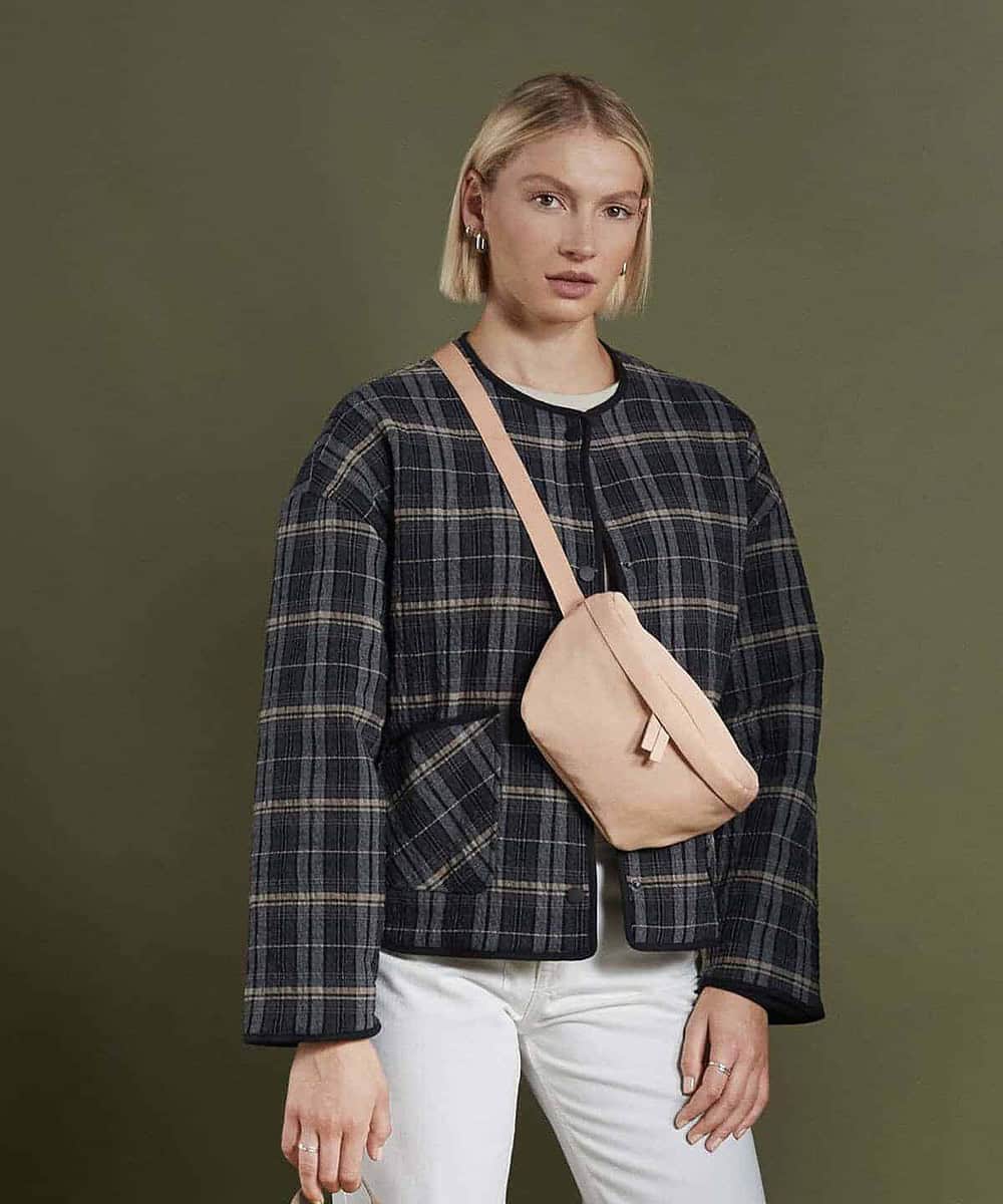 Woman wearing a nude Bagbase BG875 waistpack for casual and embroidery use.