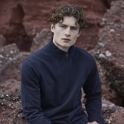 Man wearing navy blue quarter-zip pique top outdoors.