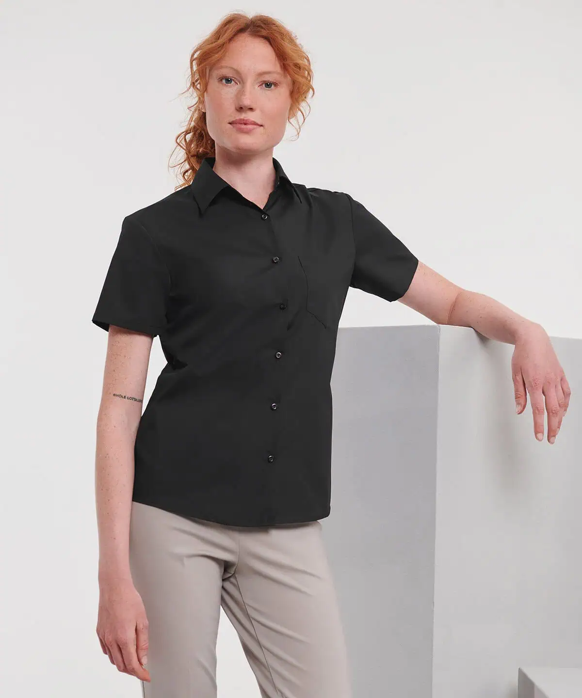 Poloshirt for workwear with embroidered logo, black short-sleeve corporate uniform, professional work attire.