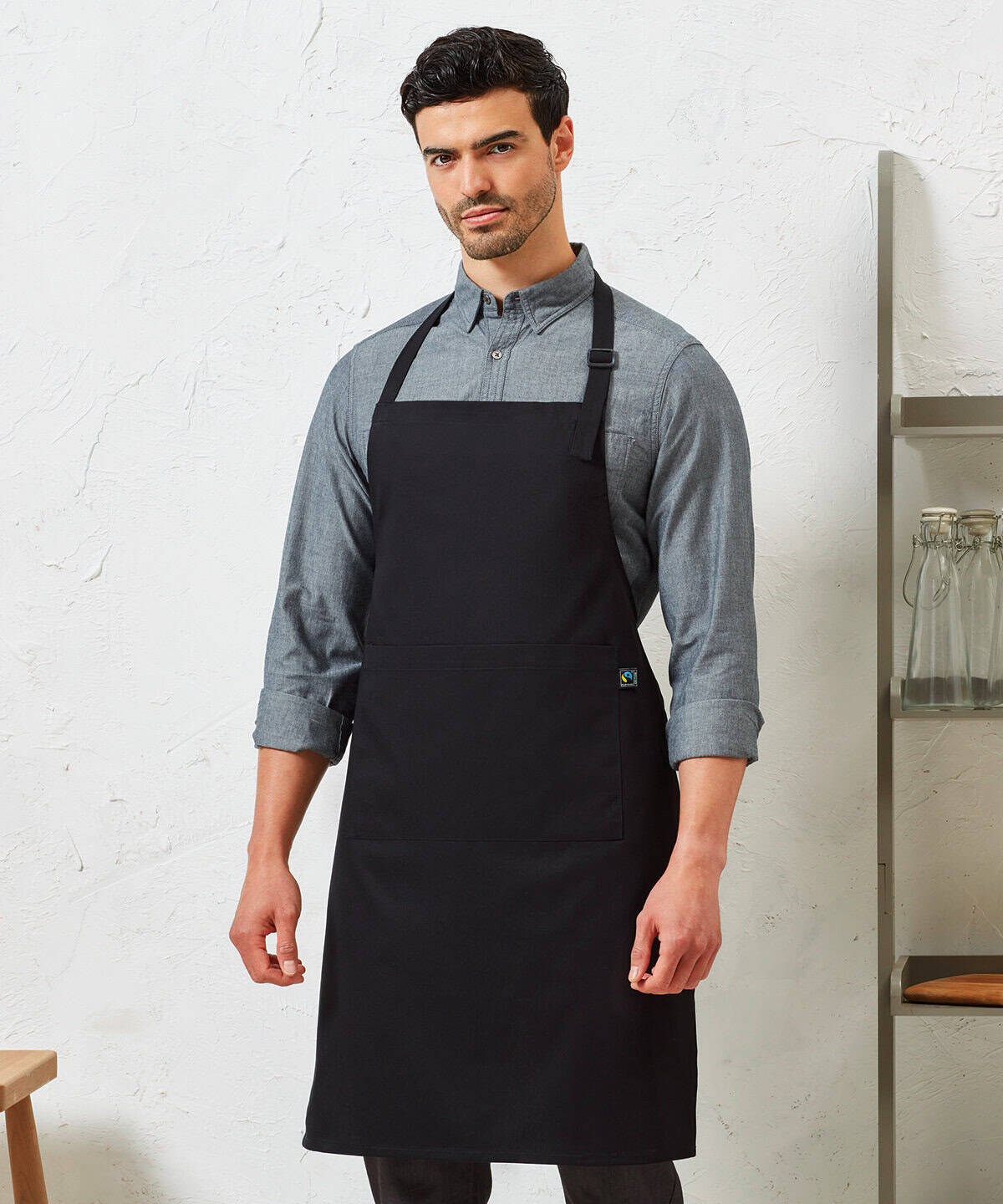 Black embroidered workwear apron with pocket, professional protective uniform for hospitality, catering, and food service workers.