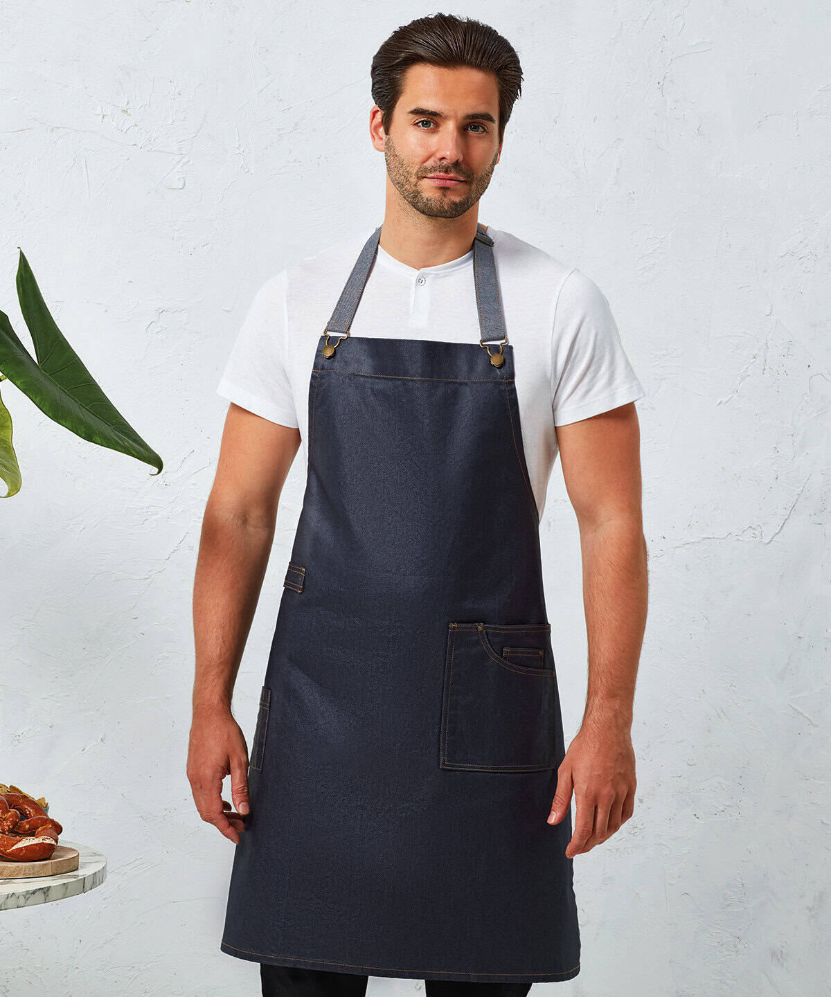 Men wearing dark denim apron for workwear, adjustable neck strap, front pocket, personalised embroidery options available.