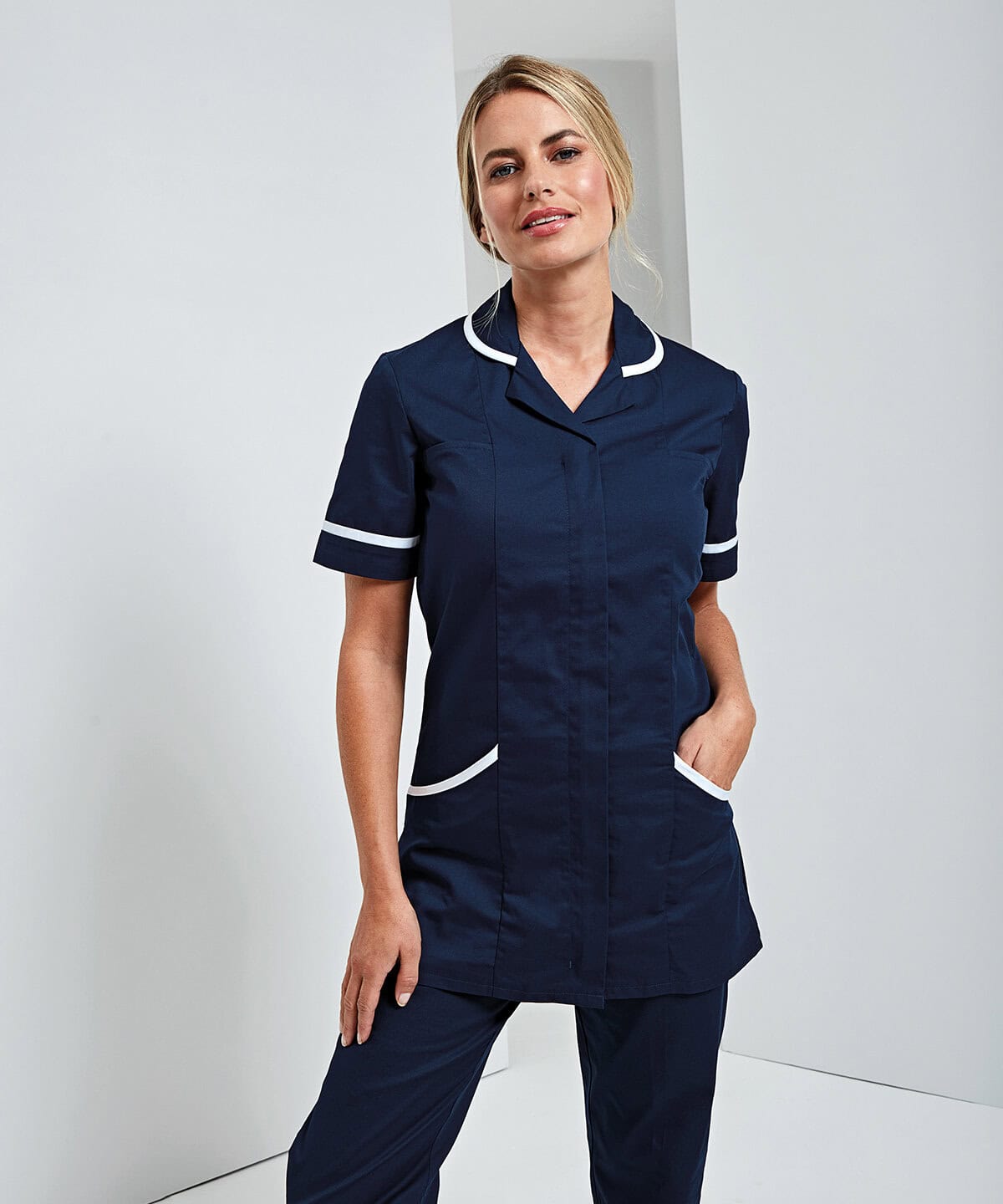 Elegant navy blue nurse uniform with white piping, short sleeves, and multiple pockets, designed for professional healthcare staff. Perfectly embroidered workwear for hospitals and clinics.