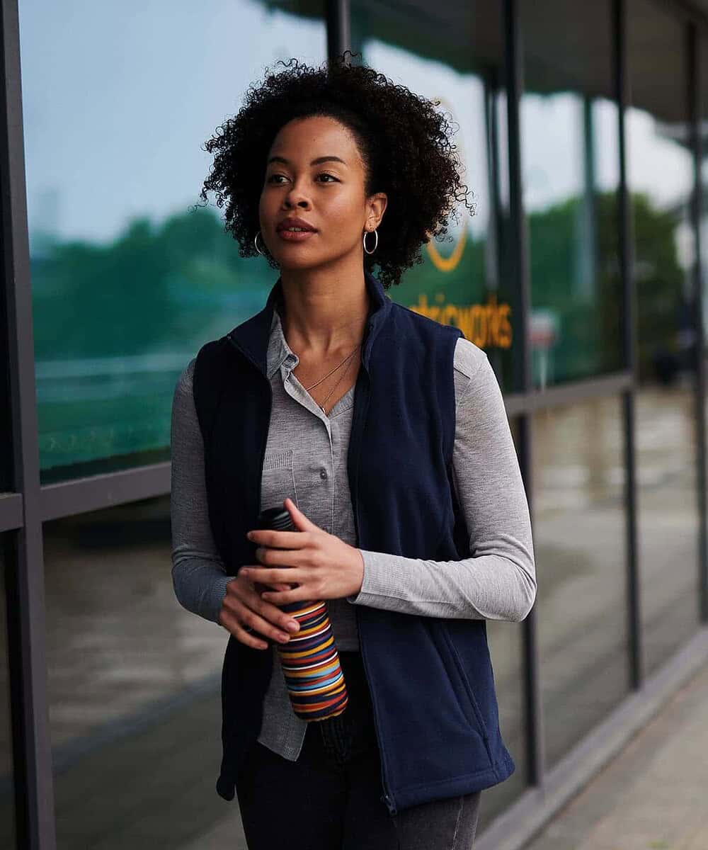 Woman wearing a navy blue microfleece bodywarmer outside.