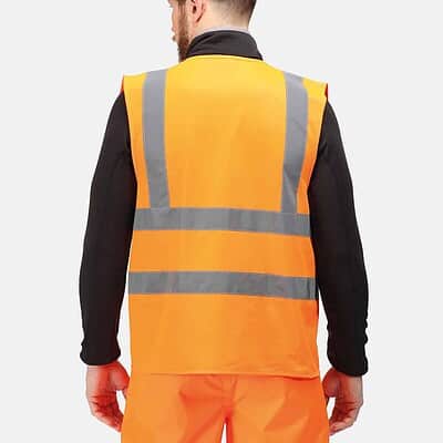 Man wearing a bright orange high visibility safety vest with reflective stripes.