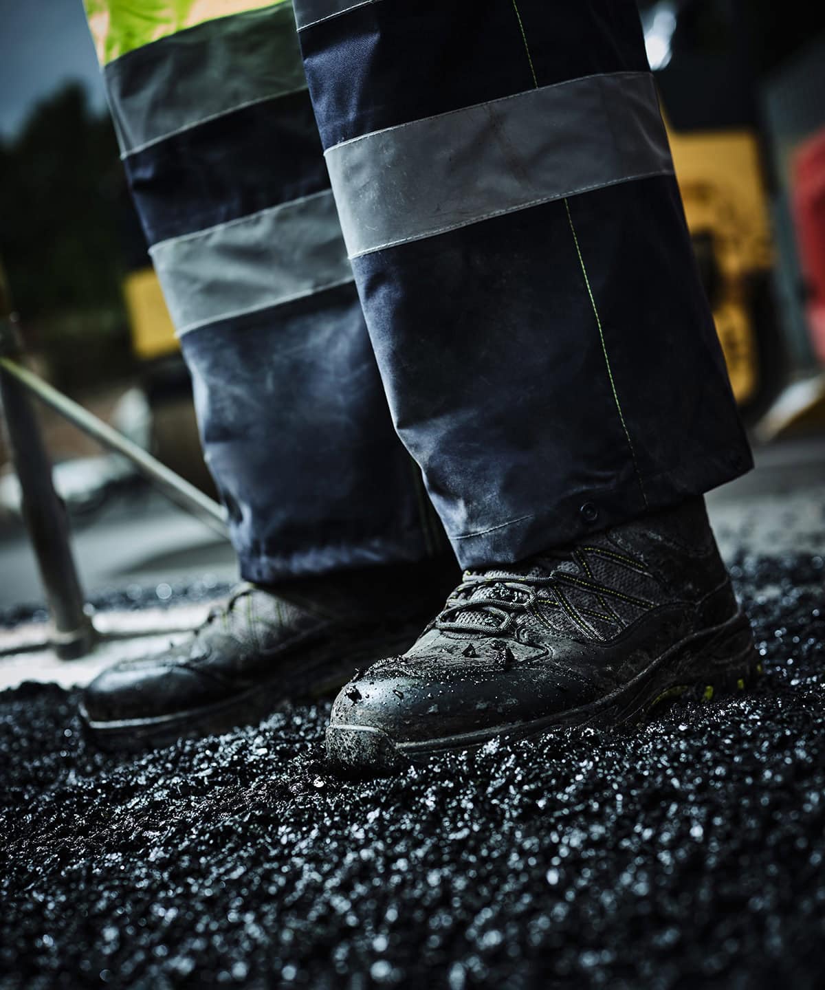 Waterproof work boots with reflective strips on workwear trousers, suitable for industrial or construction safety.