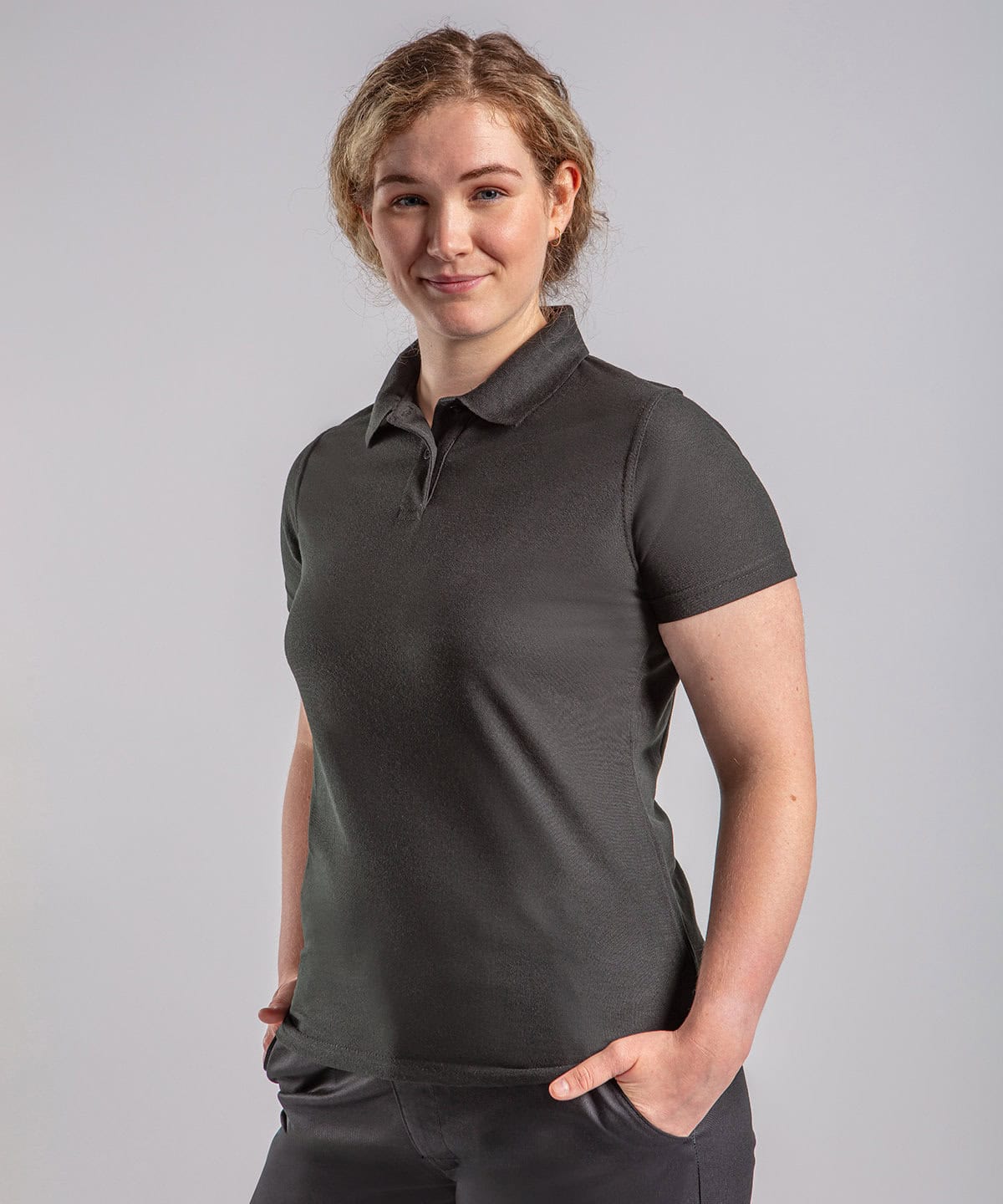RX05F Womens pro polyester polo 1 Bright young woman wearing personalised embroidered workwear polo shirt, professional corporate uniform with custom logo embroidery, suitable for work, business, or staff uniforms in grey color.