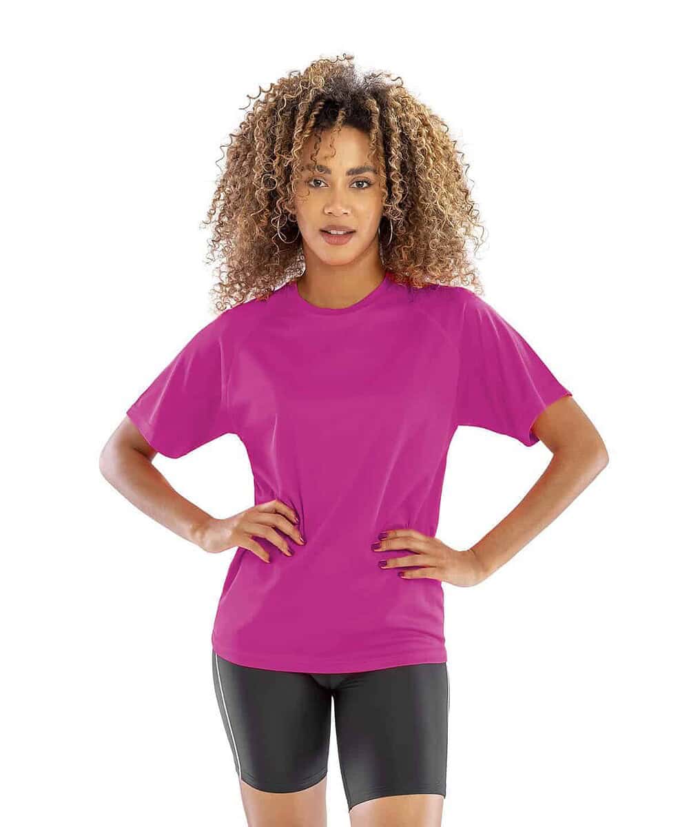 A woman wearing a bright pink Spiro S287X Performance Aircool Tee for workwear.