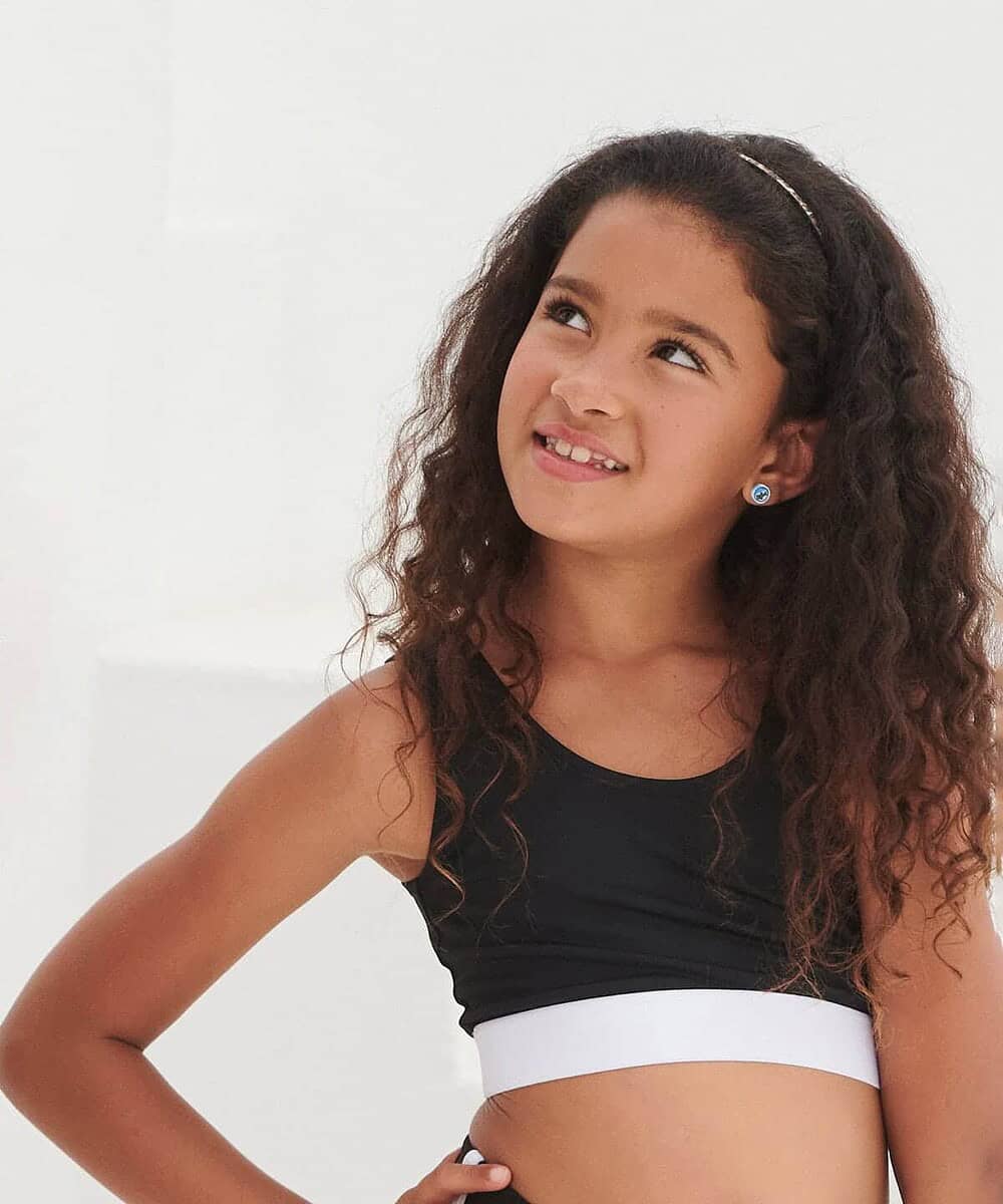 Bright young girl wearing a black and white crop top, ideal for school uniforms and casual wear.