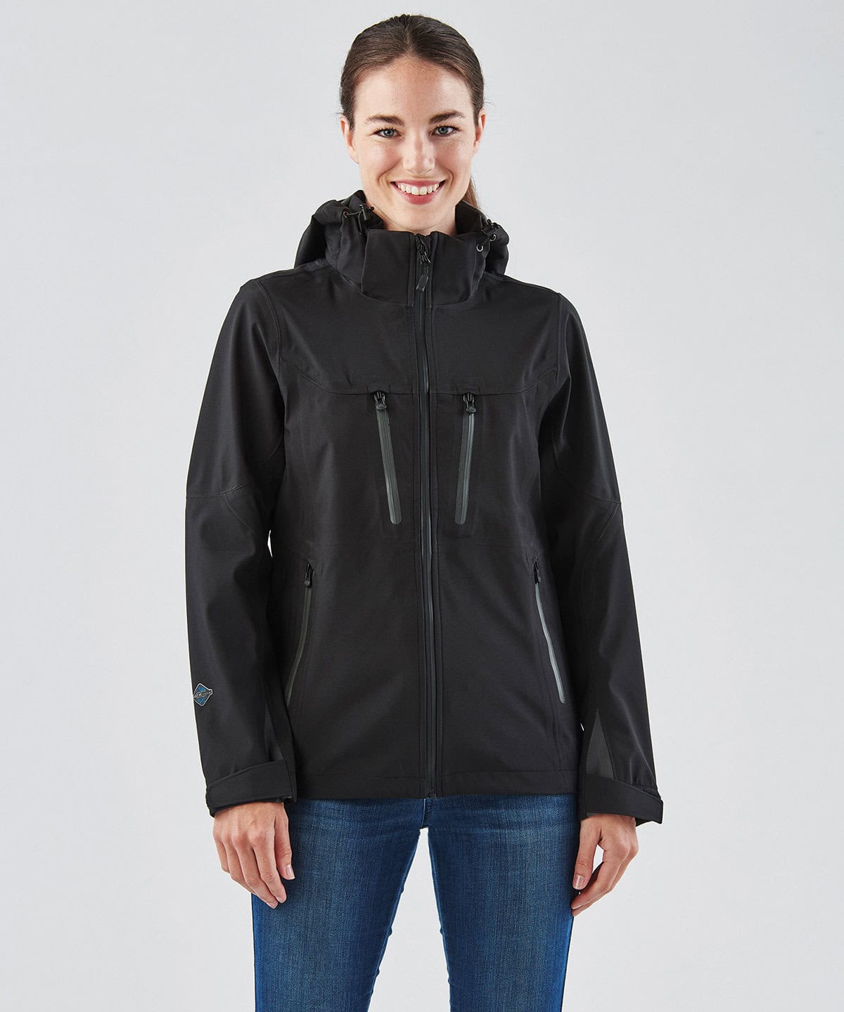 Waterproof black softshell jacket with multiple zippered pockets, ideal for workwear and outdoor uniforms, customizable with embroidery.