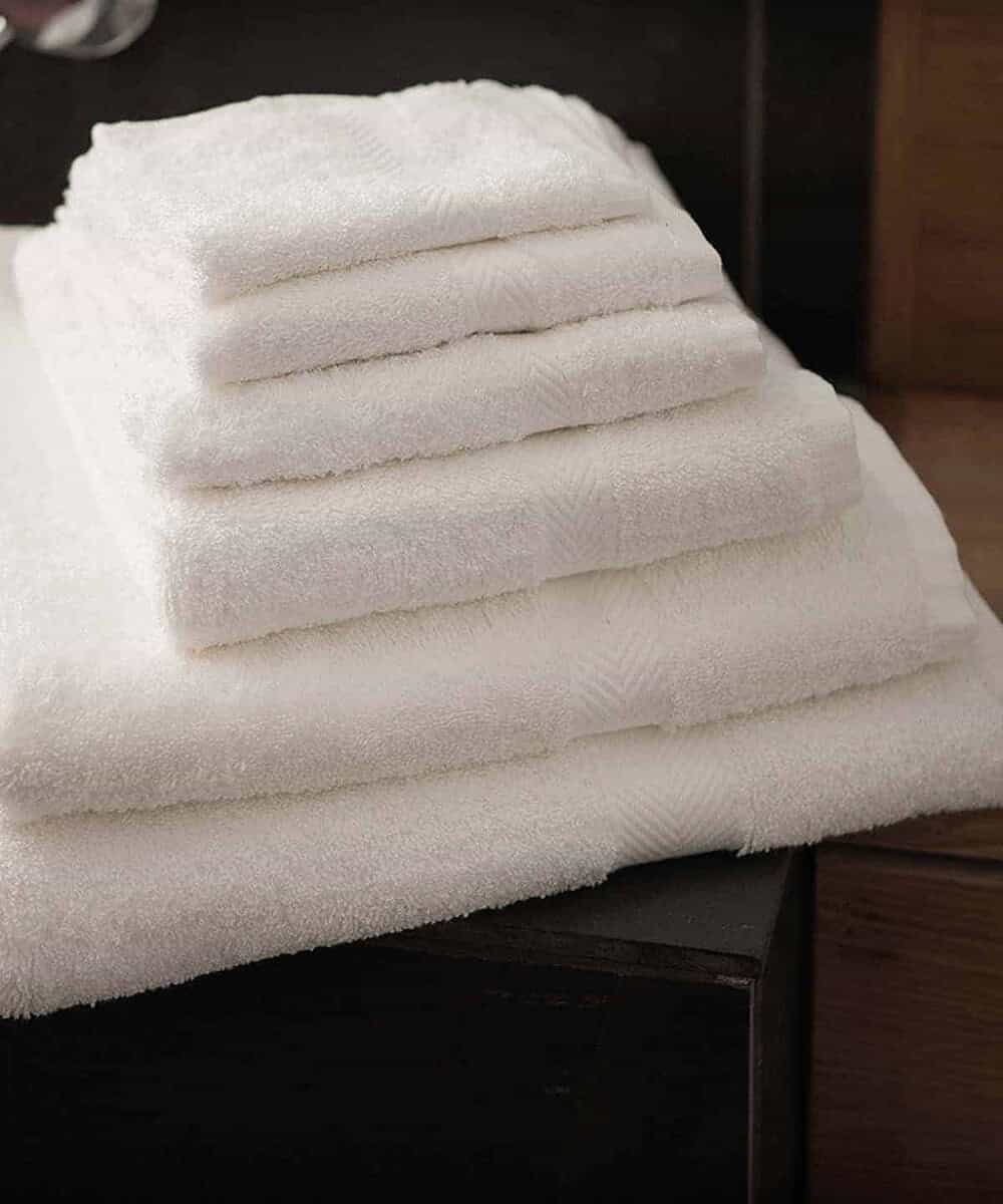 Soft white luxury guest towels stacked, ideal for hotels and spas.