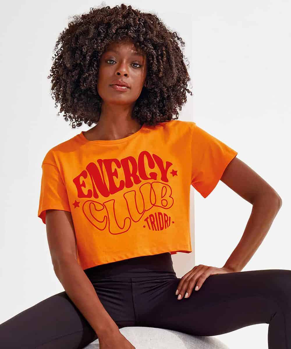 Bright orange women's crop top with "Energy Club" logo in red and yellow.