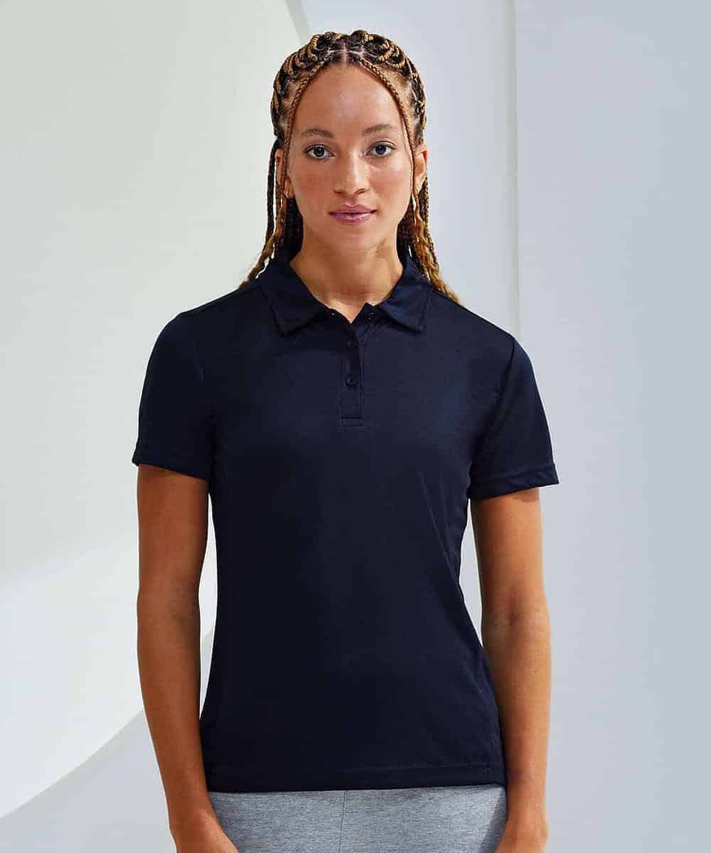 Woman wearing navy blue Tridri women's polo with logo embroidery.