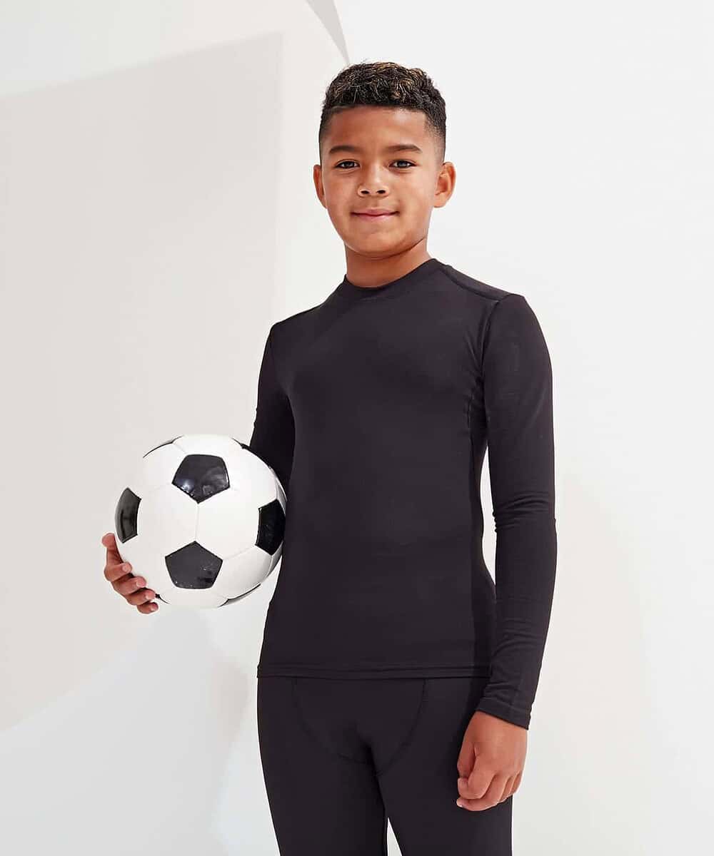 Young boy wearing black Tridri® TR16B Baselayer holding a soccer ball.