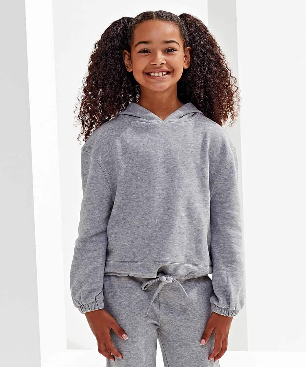 Girl wearing a grey Tridri® recycled cropped hoodie and matching joggers, smiling confidently.