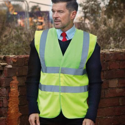 Man wearing high-visibility yellow waistcoat with reflective strips outdoors.