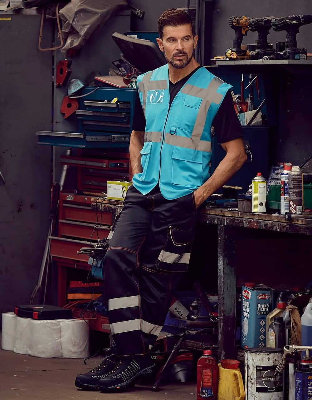 Workwear safety vest with reflective strips, suitable for industrial and construction environments. High visibility embroidered work clothing for workforce protection.