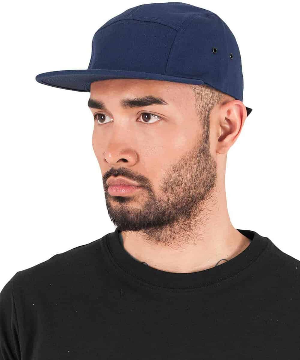 Navy blue Yupoong 5-panel jockey cap with logo embroidery, adjustable fit.