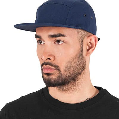 Navy blue Yupoong 5-panel jockey cap with logo embroidery, adjustable fit.