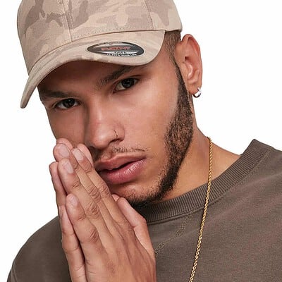 Man wearing a beige camouflage Flexfit cap with logo detail.